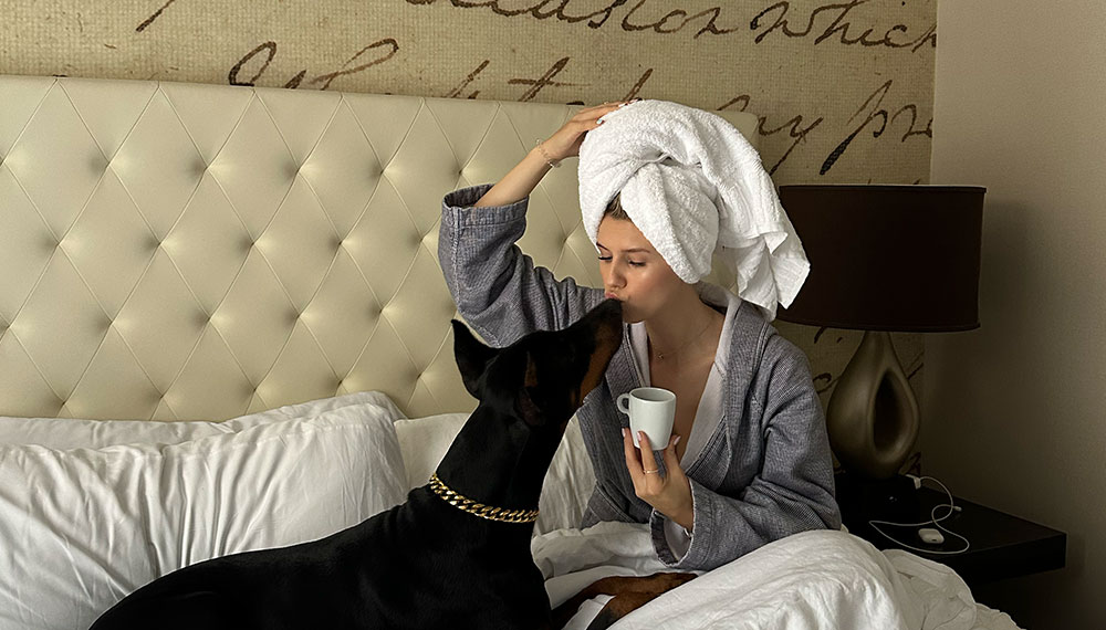 Dog and woman on hotel bed