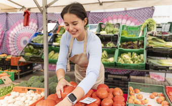 woman holding tomatoes at a farmers market